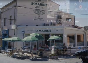 Façade et parasols verts de La Marine des Goudes sur le port à Marseille